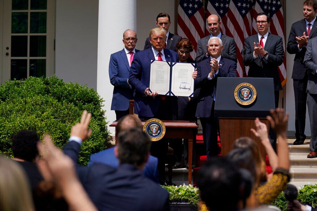 <p>FILE - In this June 5, 2020 file photo, President Donald Trump poses for a photo after signing the Paycheck Protection Program Flexibility Act during a news conference in the Rose Garden of the White House in Washington.</p>